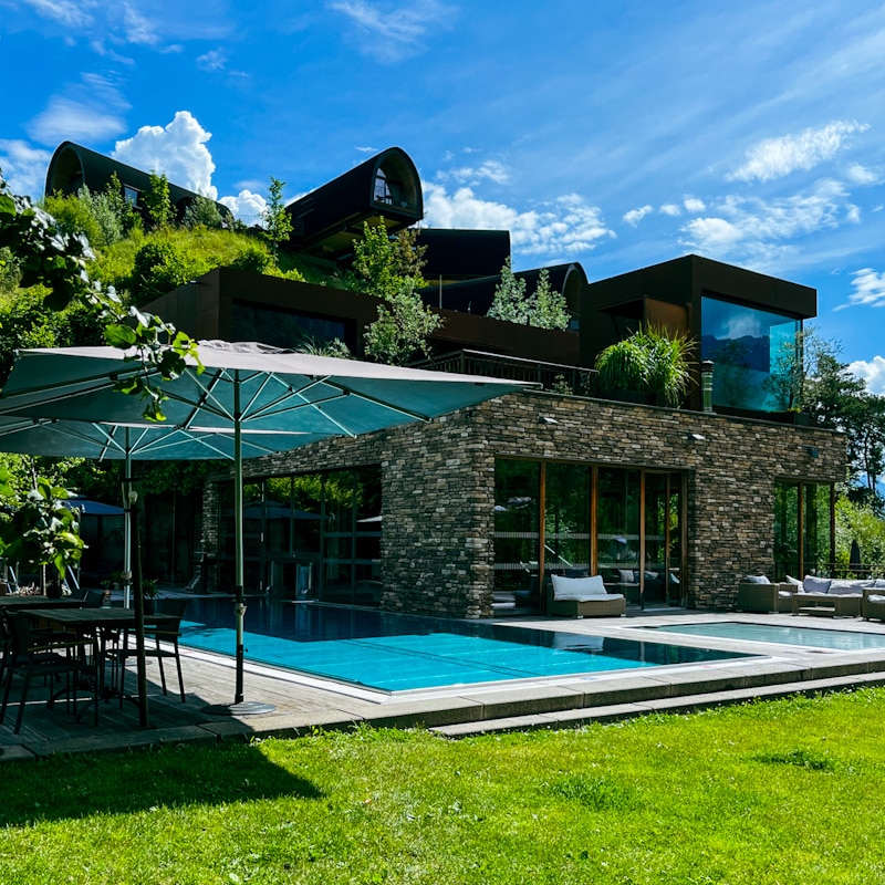 Alpencamping Nenzing – Camping mit Glamping-Gefühl in Vorarlberg 5 Pool im Alpencamping Nenzing mit Himmelschalets im Hintergrund